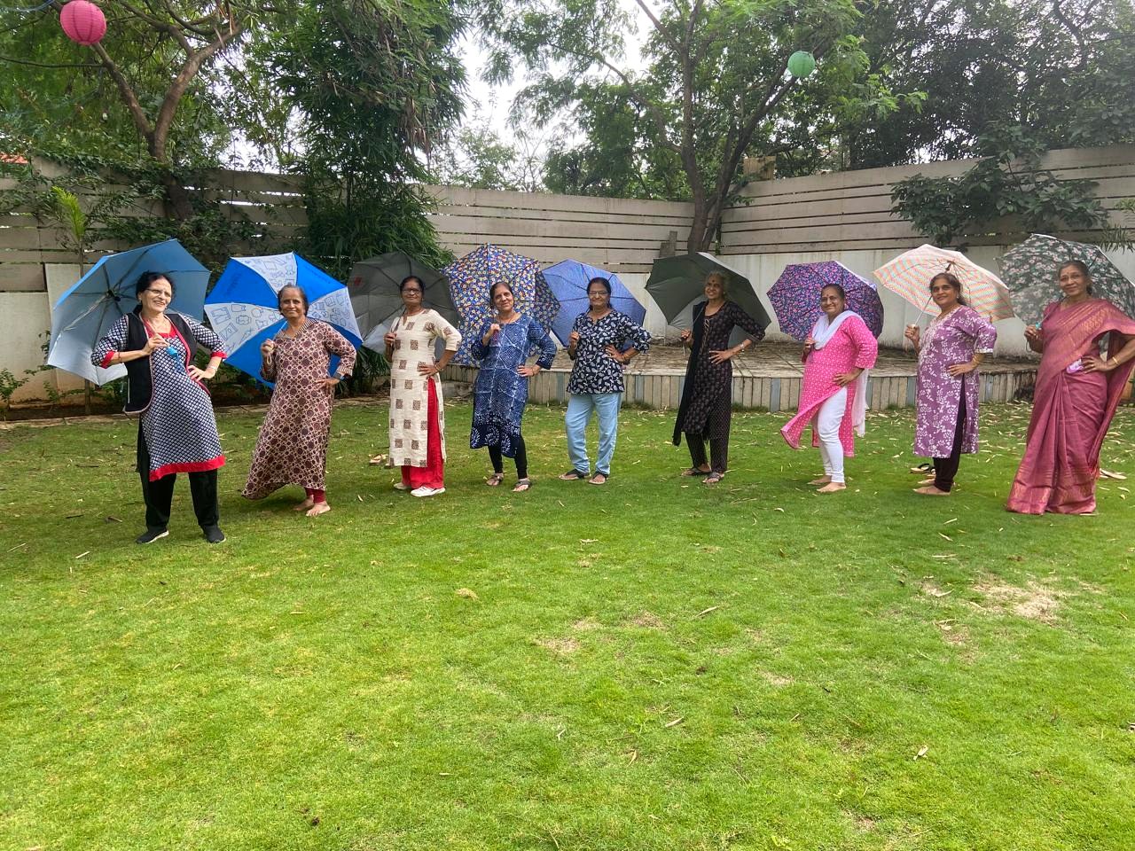 Seniors having fun with colorful umbrellas in the garden