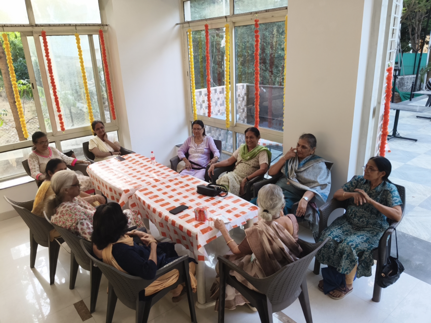 Four senior women enjoying a game of carrom at the Mahatma Society clubhouse